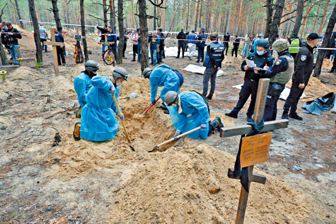 乌克兰人员在伊久姆市郊的乱葬岗挖掘尸体蒐证。　