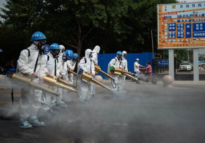 北京藍天救援隊隊員在岳各莊批發市場展開消毒工作。（新華社圖片）