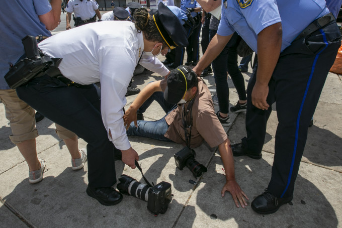 一名正在執行職務的攝影記者魯爾克過馬路時被揮拳襲擊。AP 