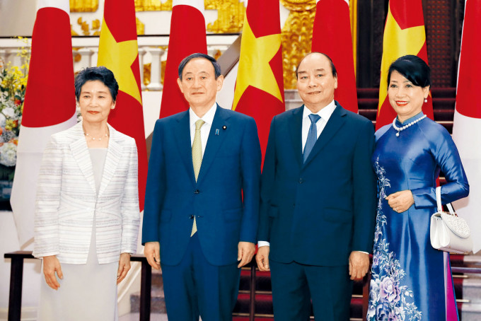 菅义伟夫妇（左）与越南总理阮春福夫妇在河内合照。