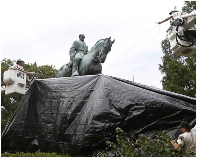 工作人員張開黑布遮蓋解放公園內的李將軍雕像。AP圖片