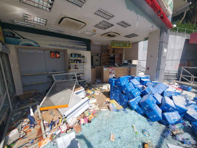 油站便利店貨物散落一地，有貨架被推倒，一地玻璃碎。