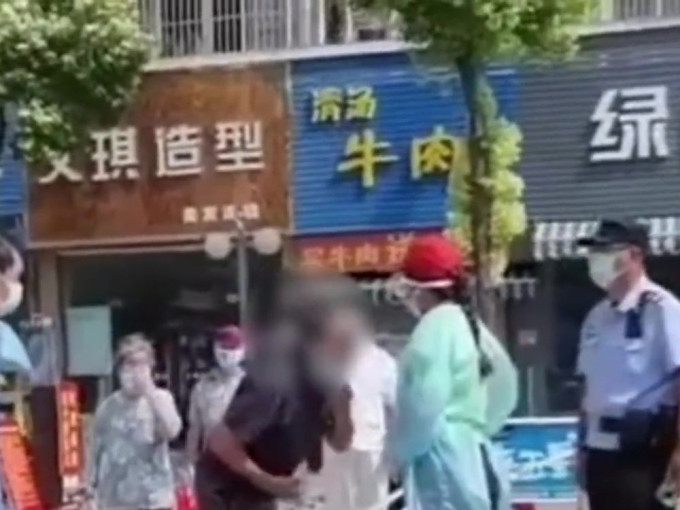 扬州老翁向检测点义工吐痰，引发网民热议。