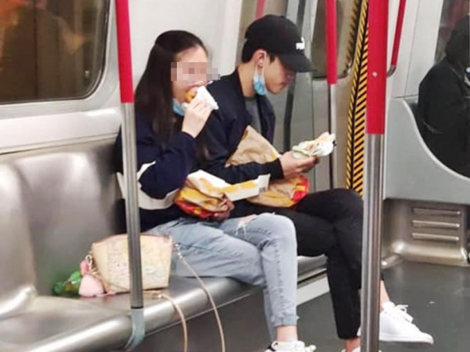 一对男女坐在港铁车厢内，公然将口罩拉低至下巴位置，吃快餐店外卖。「将军澳讨论区」Facebook图片