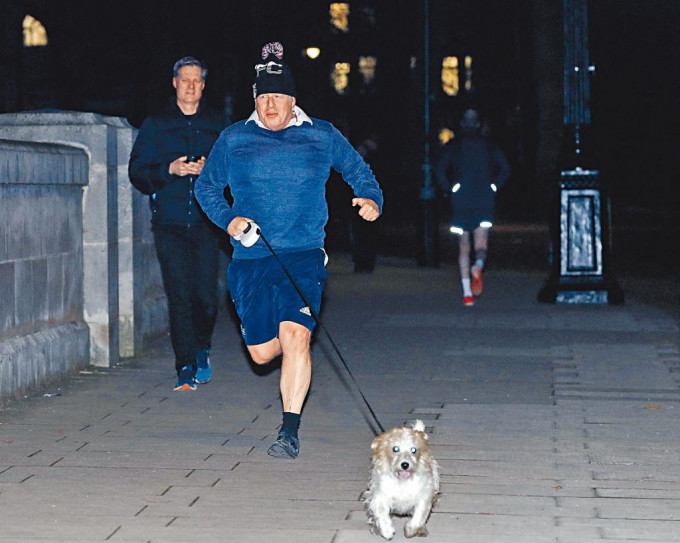 英揆约翰逊昨日在伦敦拖着爱犬缓步跑。