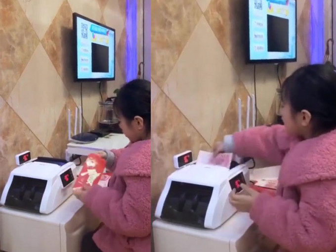 穿着粉红色外套的小女童，坐在点钞机面前，一边拆利是，一边点算钞票。（网图）