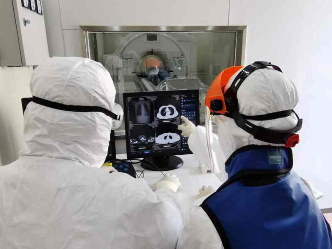 武汉医护人员使用移动CT新设备为患者检查。新华社