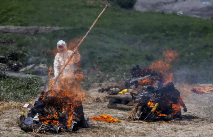 尼泊爾火葬場爆滿，工作人員在廟宇旁焚燒新冠患者遺體。AP圖片