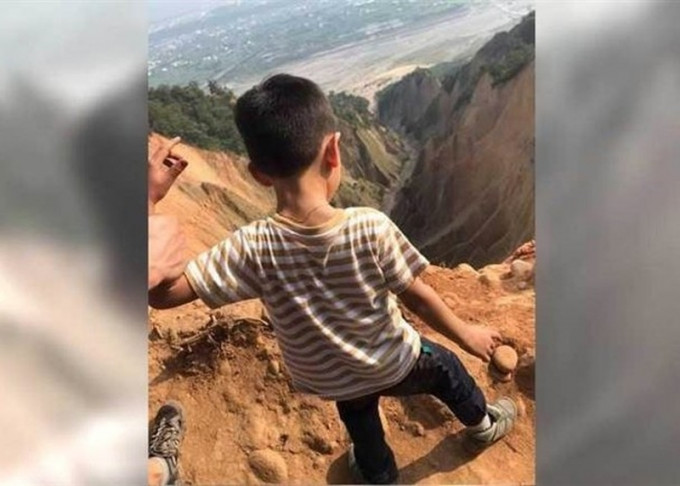 台湾有男童危站崖边拍照打卡，家长被网民炮轰辩称拍摄角度问题。(网图)