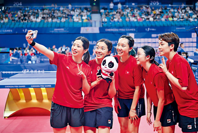 香港女子乒隊拿着吉祥物合照，盡顯童真一面。