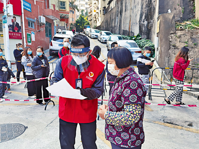 深圳龙岗有义工协助居民防疫。