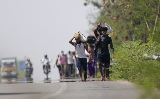 印度大批工人失业，徒步返乡。 AP图