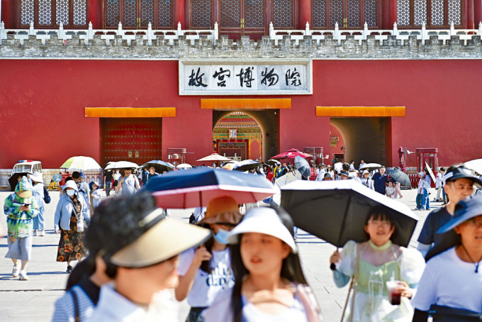 40度高温下，北京故宫游客昨日撑伞防晒。