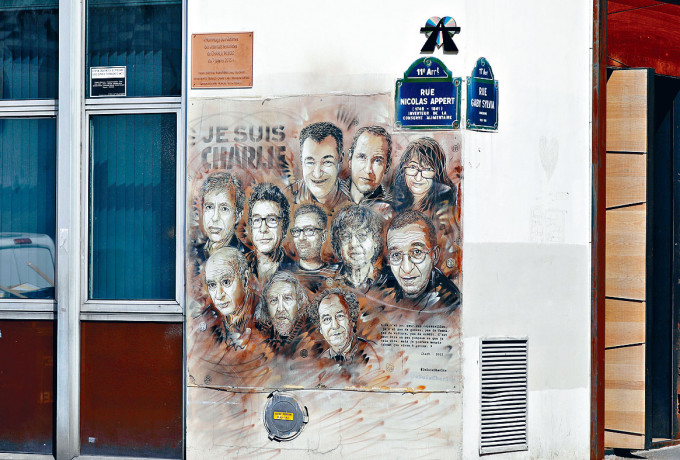 《查理周刊》雜誌社前辦公室門外，貼上遭屠殺員工的肖像畫。