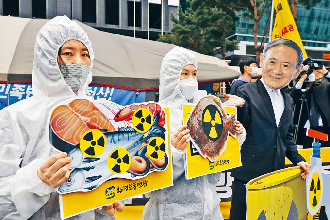 环保分子周二在首尔示威，戴上日相菅义伟的面具抗议排放核废水。