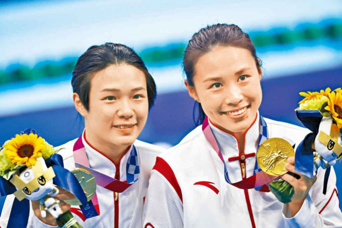 中国跳水组合施廷懋（左）与王涵拿着金牌合照。