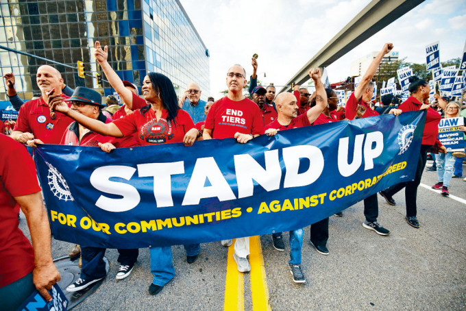 全美汽車工人聯合會主席費恩（中）上周五與工會成員在底特律遊行，支持罷工工人。