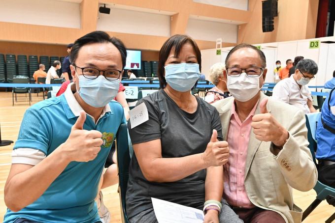 聶德權（左）、西貢區滅罪委員會主席吳仕福（右）與市民（中）一同支持疫苗接種計劃。政府新聞處