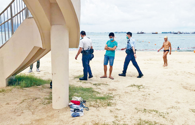 警員在沙灘調查，發現女死者遺下物品。