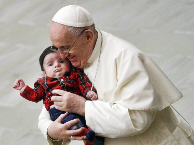 教宗方济各曾不戴口罩抱著一名婴儿。AP图片