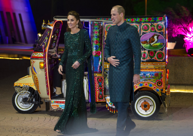 威廉和凱特穿上當地傳統服飾，搭乘三輪嘟嘟車赴宴會。 AP