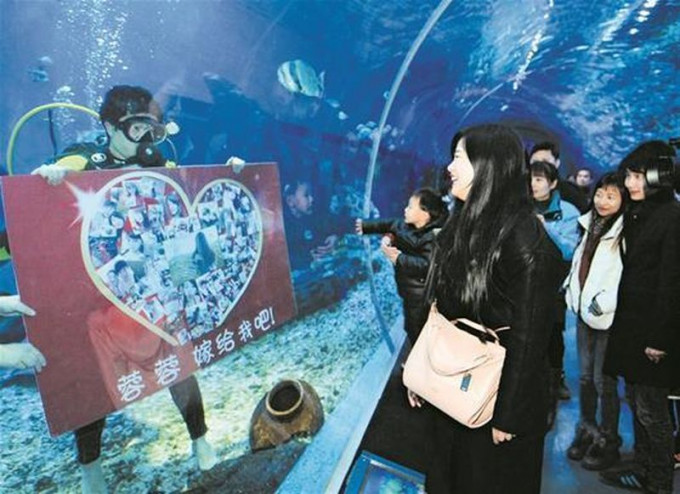李林牧在大水缸内举起大心横额：「蓉蓉，嫁给我吧」。图：腾讯