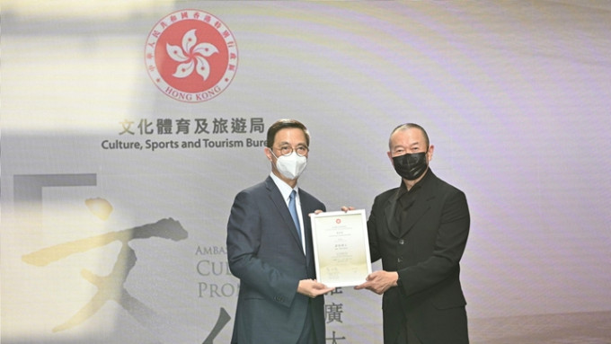 楊潤雄(左)委任國際著名華人作曲家譚盾(右)為「文化推廣大使」。政府新聞處圖片