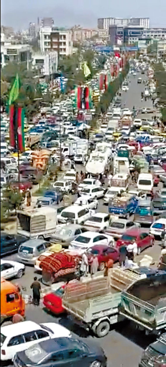 阿富汗首都喀布爾大馬路上周日滿是車輛，大批心急逃離的民眾塞在路中心。