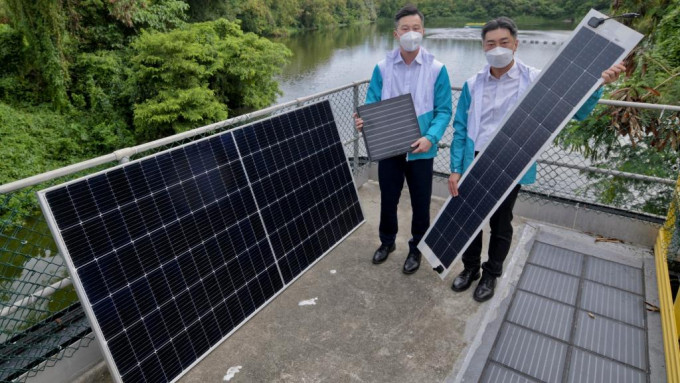 呂振龍（左）展示新田蓄洪池內安裝的浮式、柔韌式和可踏式太陽能板。陳浩元攝