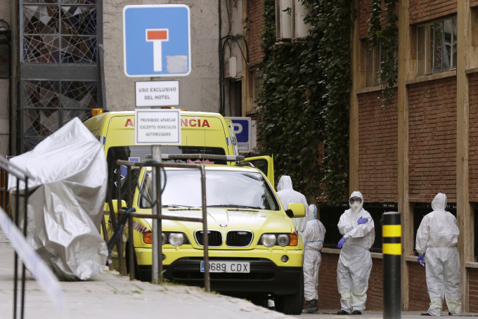 西班牙医护人员从酒店移送患者到医院。 AP