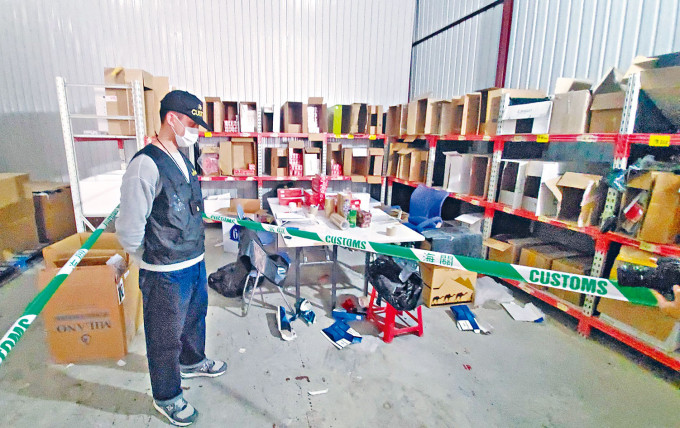 执法人员在货仓检获大批私烟及包装工具。