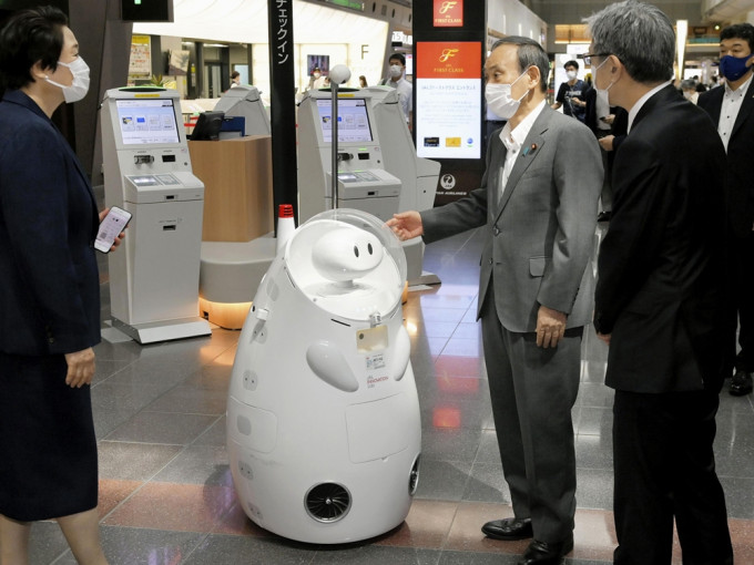 日本首相菅义伟(右二)周一（28日）视察东京羽田机场。AP图片