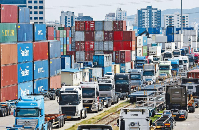 南韓京畿道義王陸路貨櫃中轉站周一泊滿罷工司機的貨車，貨櫃堆積如山。
