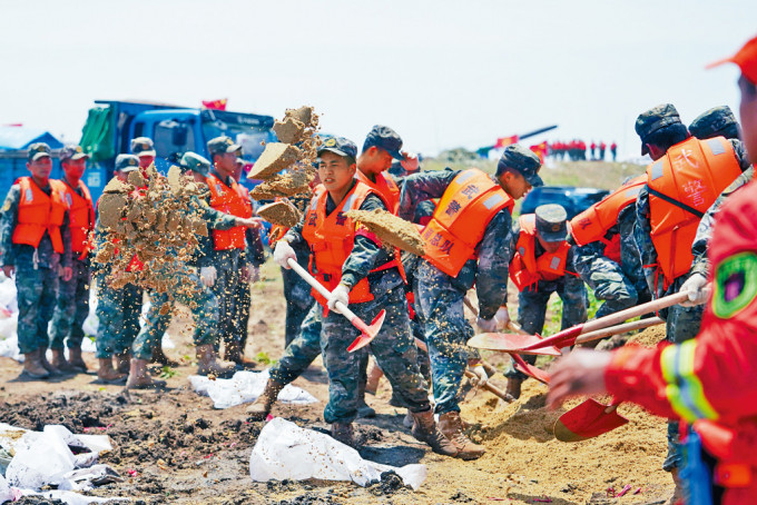 武警、消防员等在洞庭湖第二道防线进行紧急处置。