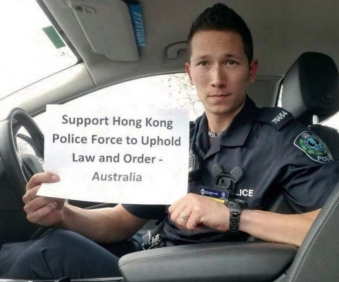 身穿制服的澳洲警員在車內展示撐港警標語。
