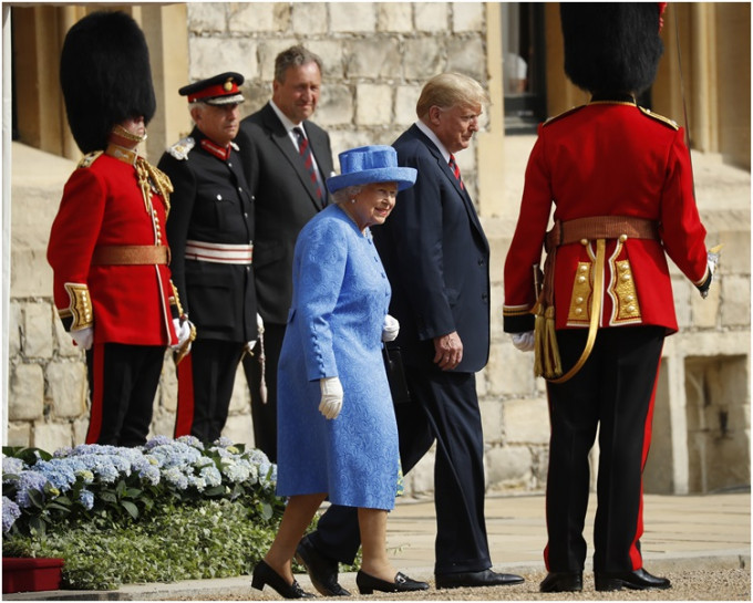检阅衘林军时特朗普走在英女皇前将遮她挡。AP