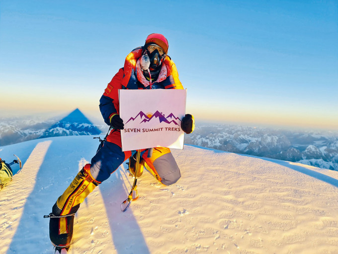 ■攀山队员谢尔帕上周六手持队旗在K2峰顶拍照。