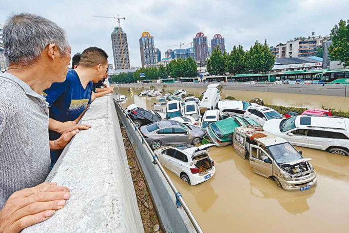 数十辆汽车被洪水冲挤在一起。　