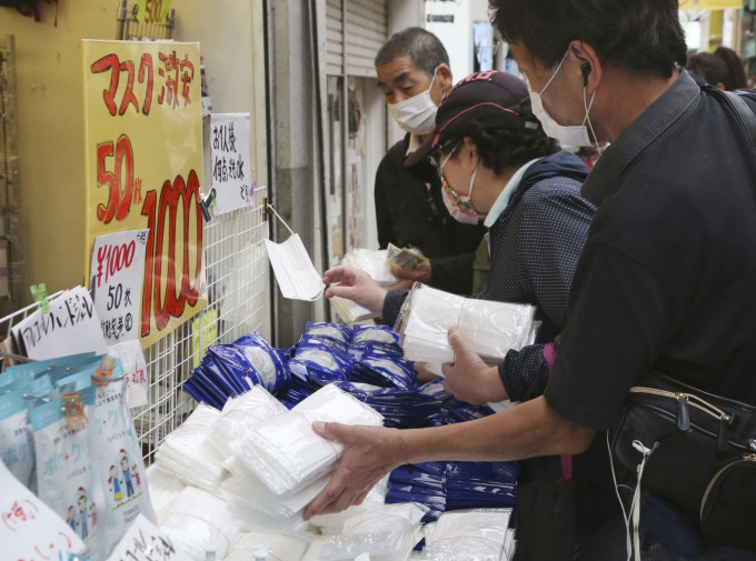 在新冠疫情下，日本民眾選購口罩等物品。AP