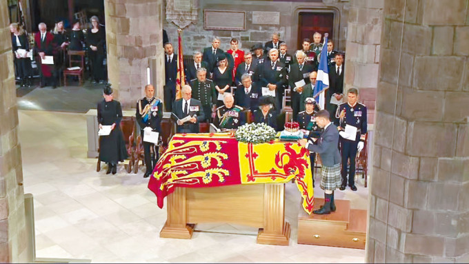 在愛丁堡聖吉爾斯大教堂，英皇查理斯三世伉儷等皇室成員，昨午見證蘇格蘭皇冠置於女皇靈柩上。