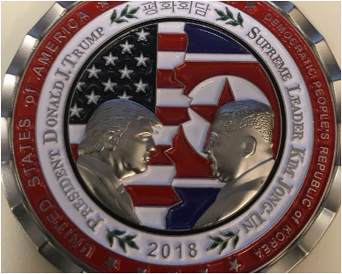 硬幣背景是兩國國旗，還有白宮及空軍一號等圖案。