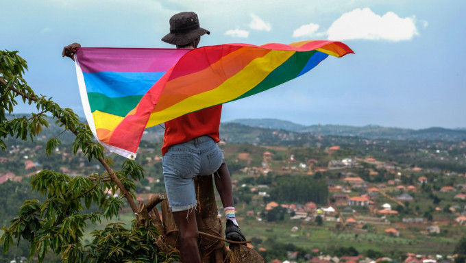 一名烏干達男子手持象徵性小眾的彩虹旗。 美聯社