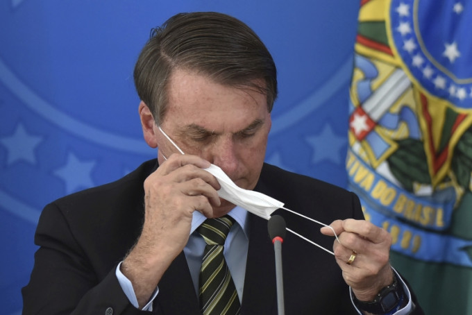 巴西總統博爾索納羅記者會上戴上口罩。AP
