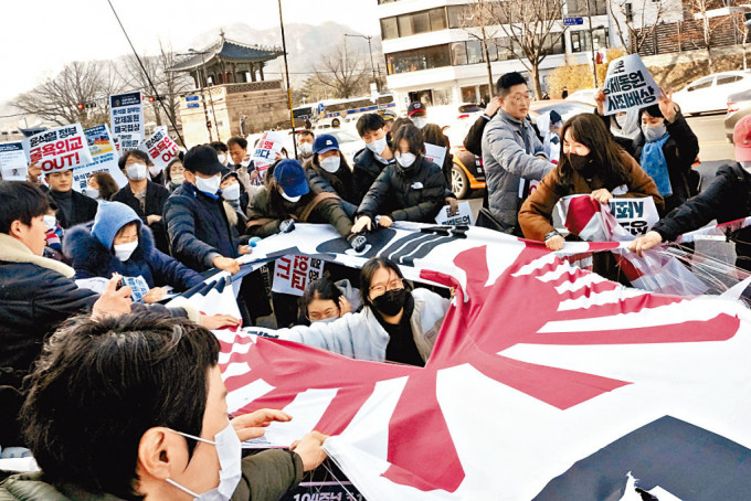 示威者上周三在首尔的日本大使馆外，撕毁日本旭日旗。