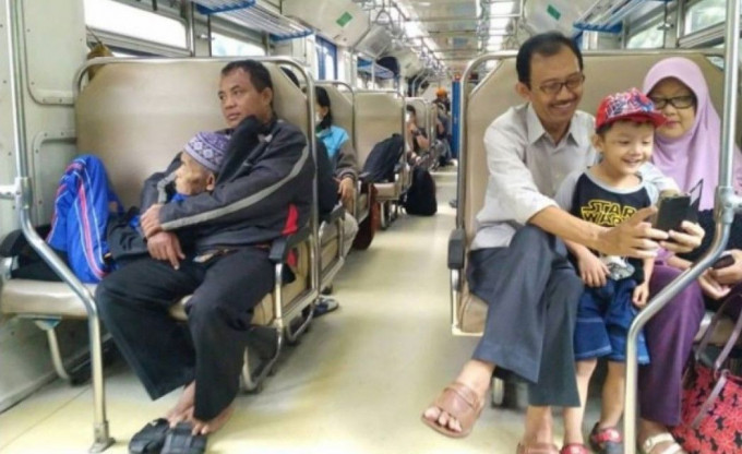 印尼男火车拍照记录父子情。网上图片