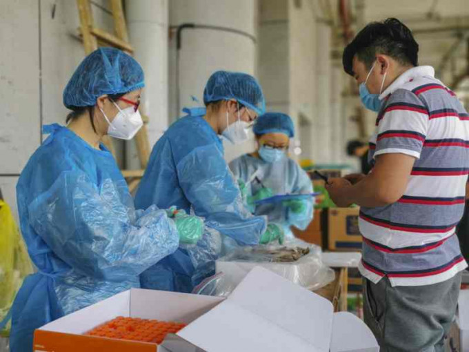 烏魯木齊市疾控中心對海鮮市場外環境進行採樣。新華社