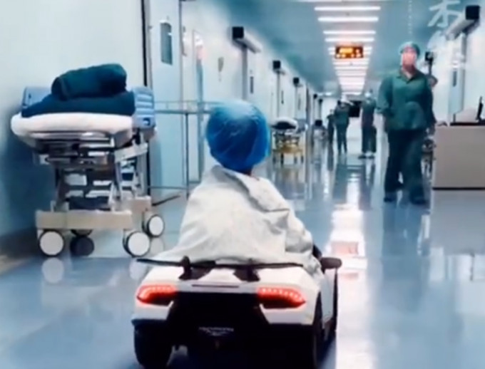 医院用玩具车接孩子进手术室。微博影片截图