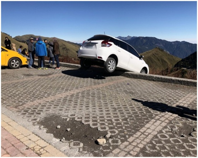 車子一半在護欄外，還幸有驚無險。