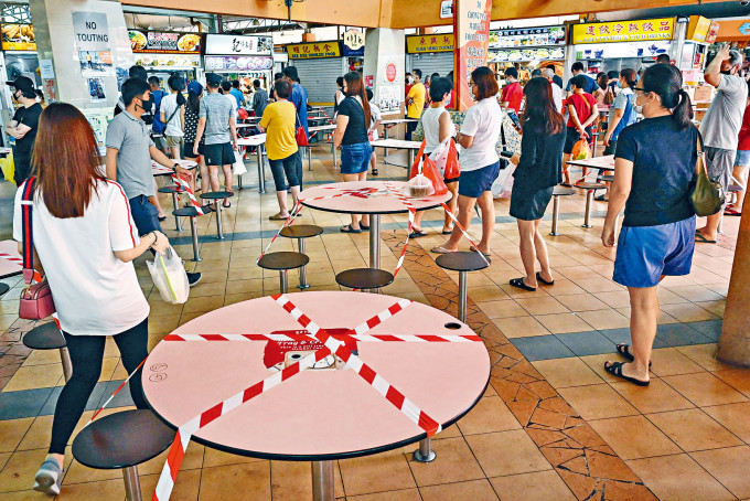 新加坡昨日起所有餐饮场所禁止堂食，顾客排队外买。　