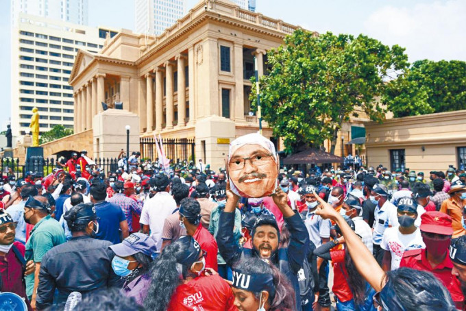 斯里蘭卡示威者上周五戴上總統拉賈帕克薩的面具遊行，抗議物價上漲。
